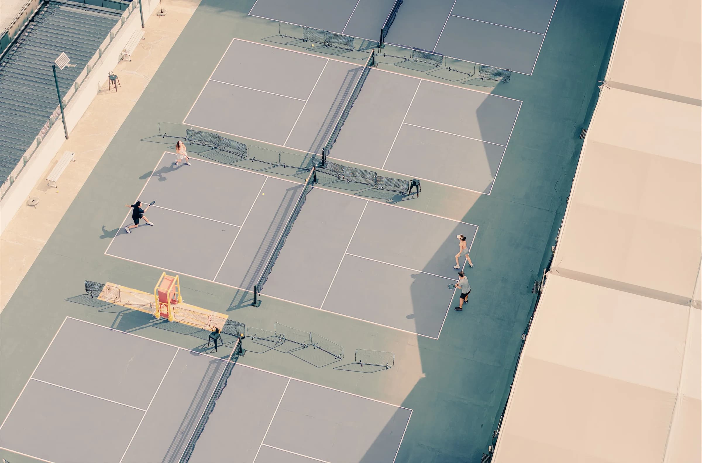 Pickleball players on outdoor courts viewed from above